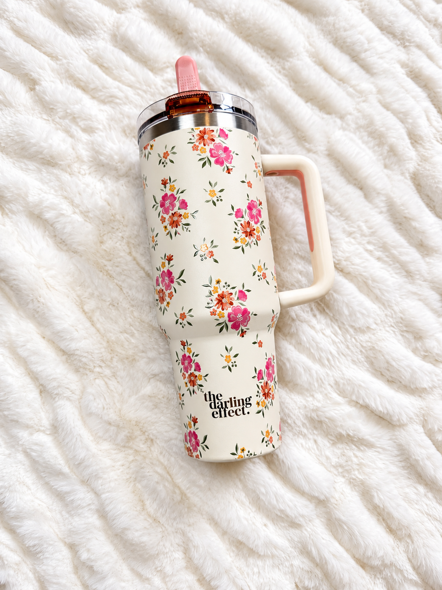 The Daydream Floral Tumbler, a cream 40 oz tumbler with pink and coral flowers and a blush flip straw