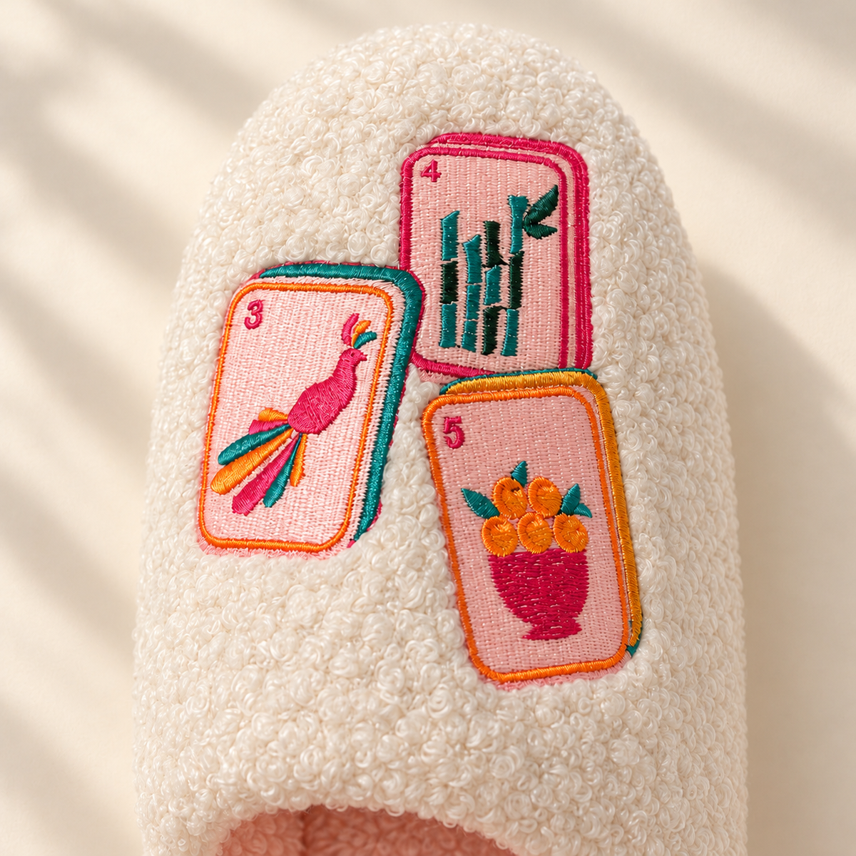 Close-up of the embroidered mahjong tiles on the Dot, Crack & Bam slippers