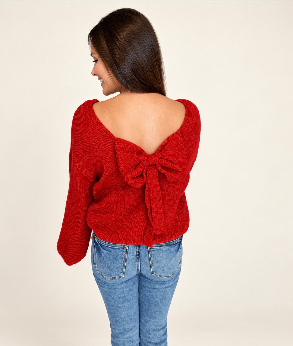 Back view of The Belle Bow Sweater, red knit with a large bow across the open back