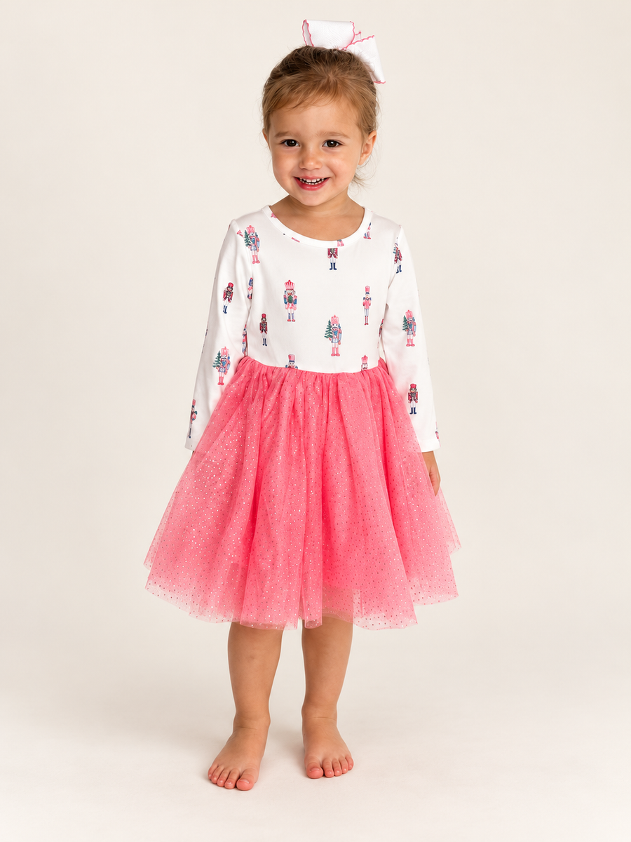 Girl wearing The Nutcracker Twirl Dress, ivory nutcracker bodice and pink tulle skirt