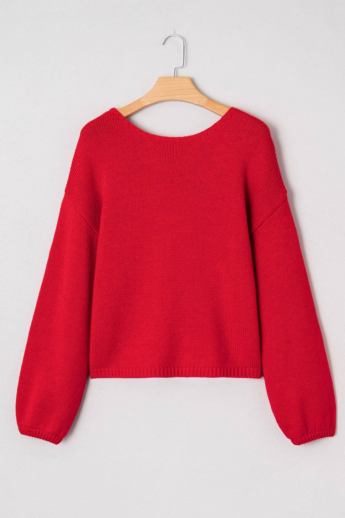 The Belle Bow Sweater on a hanger, front view